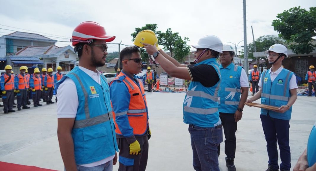 General Manager PLN UID Sumut, Agus Kuswardoyo memakaikan Helm kepada pelayanan teknik. (Dok/PLN)