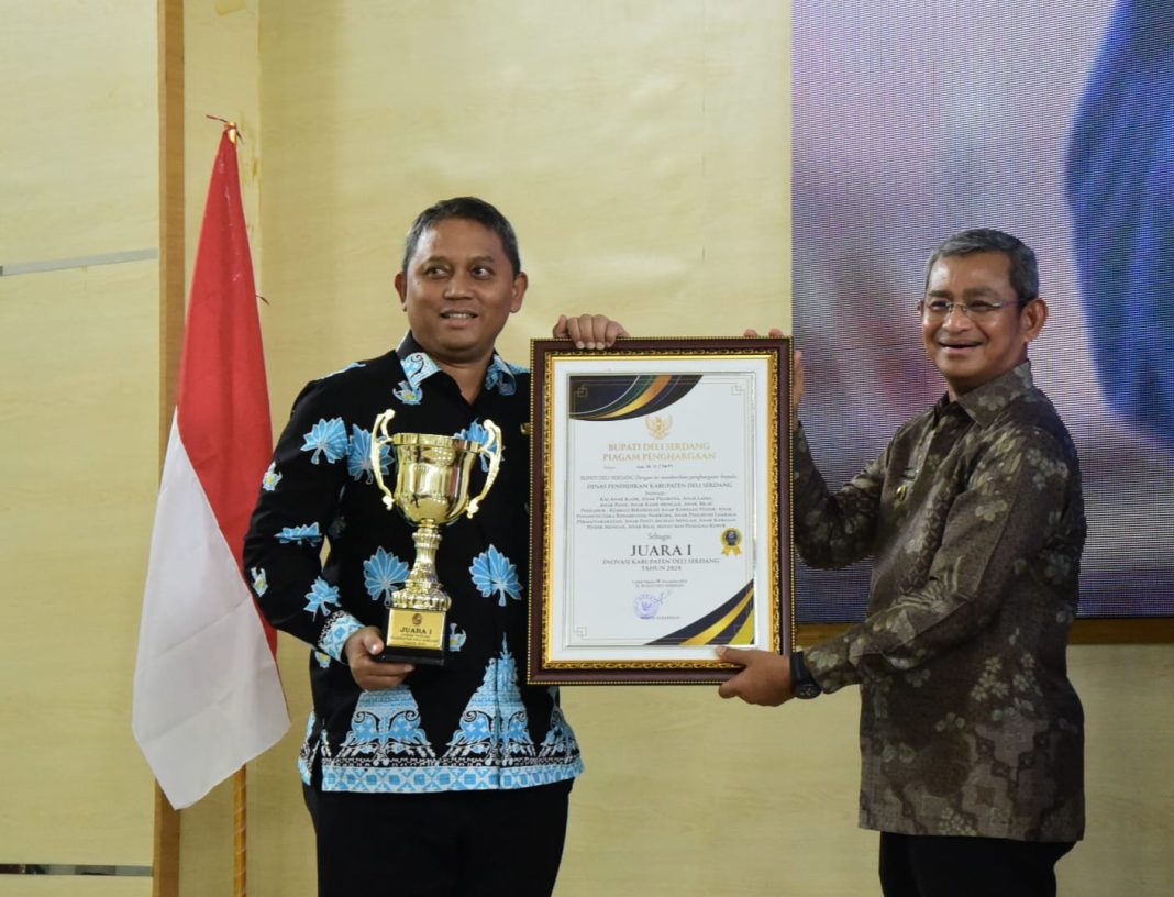 Pj Bupati Deliserdang Wiriya Alrahman menyerahkan anugerah loba inovasi ke Kadis Pendidikan Yudy Hilmawan di Lubukpakam, Kamis (21/11/2024). (Dok/Kominfo Deliserdang)