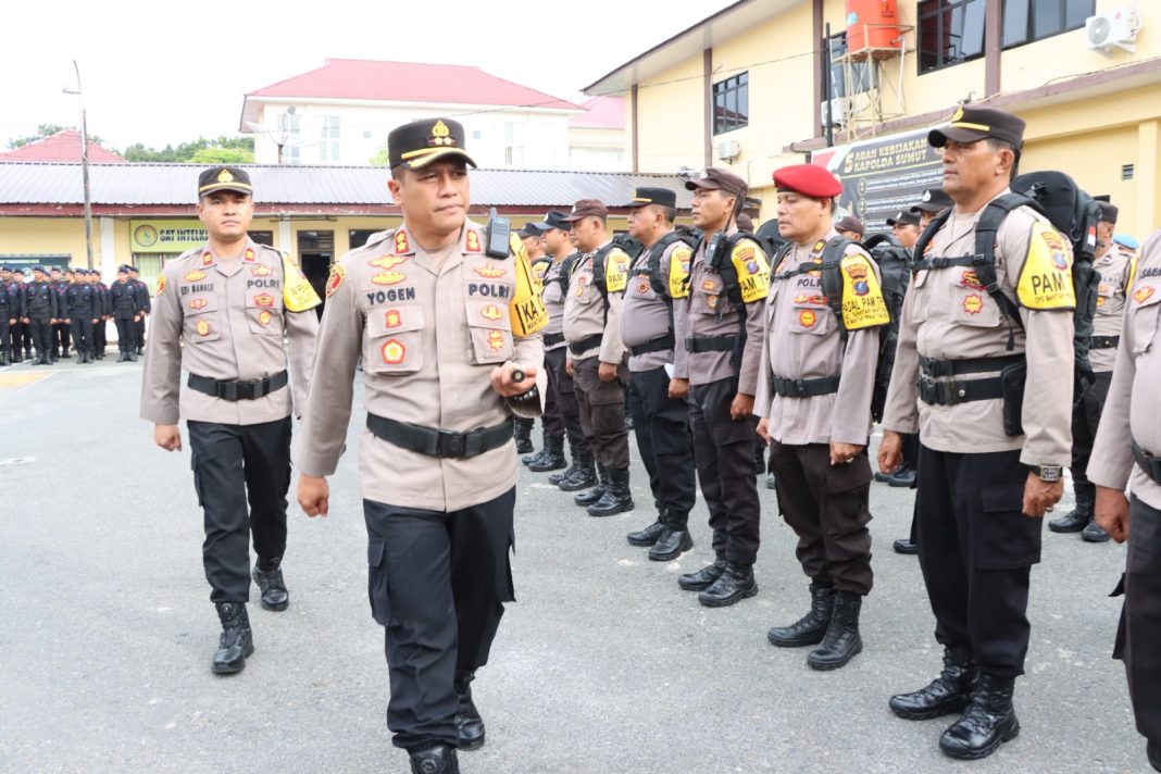 Kapolres Pematangsiantar AKBP Yogen Heroes Baruno memeriksa pasukan saat memimpin apel pergeseran personel dalam rangka Pam pemungutan suara Pilkada serentak tahun 2024 bertempat di Lapangan Mako Polres Pematangsiantar, Senin (25/11/2024). (Dok/Polres Pematangsiantar)