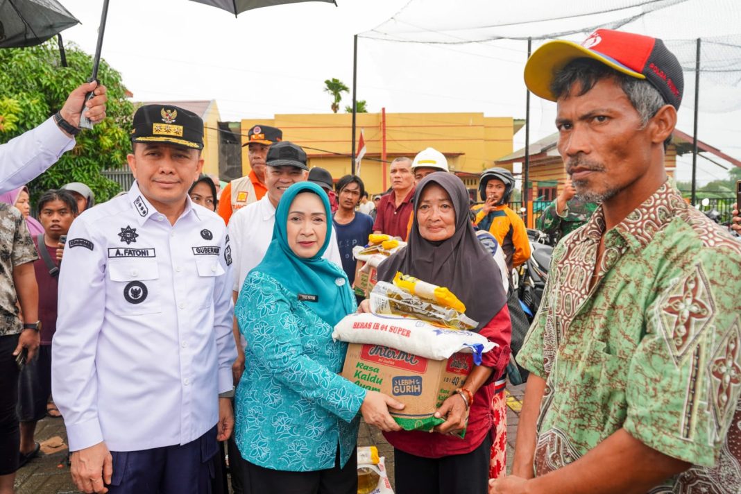 Pj Gubernur Sumut Agus Fatoni bersama Pj Ketua PKK Tyas Fatoni menyerahkan bantuan usai meninjau korban banjir yang tinggal di Jalan Desa Suka Makmur, Kabupaten Deliserdang, Rabu (27/11/2024). (Dok/Diskominfo Sumut)