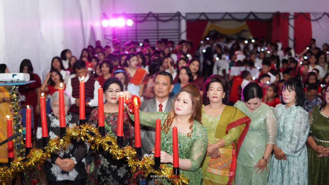 Perwakilan Komite Sekolah, Gracesiela Y Simanjuntak SE MSi menyalakan lilin Natal saat perayaan Natal keluarga besar PKIM tahun 2024 di Aula PKIM, Kamis (12/12/2024).