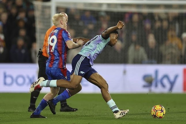 Will Hughes (kiri) mencoba merebut bola dari kaki Myles Lewis Skelly di laga Crystal Palace vs Arsenal, Minggu (22/12/2024).