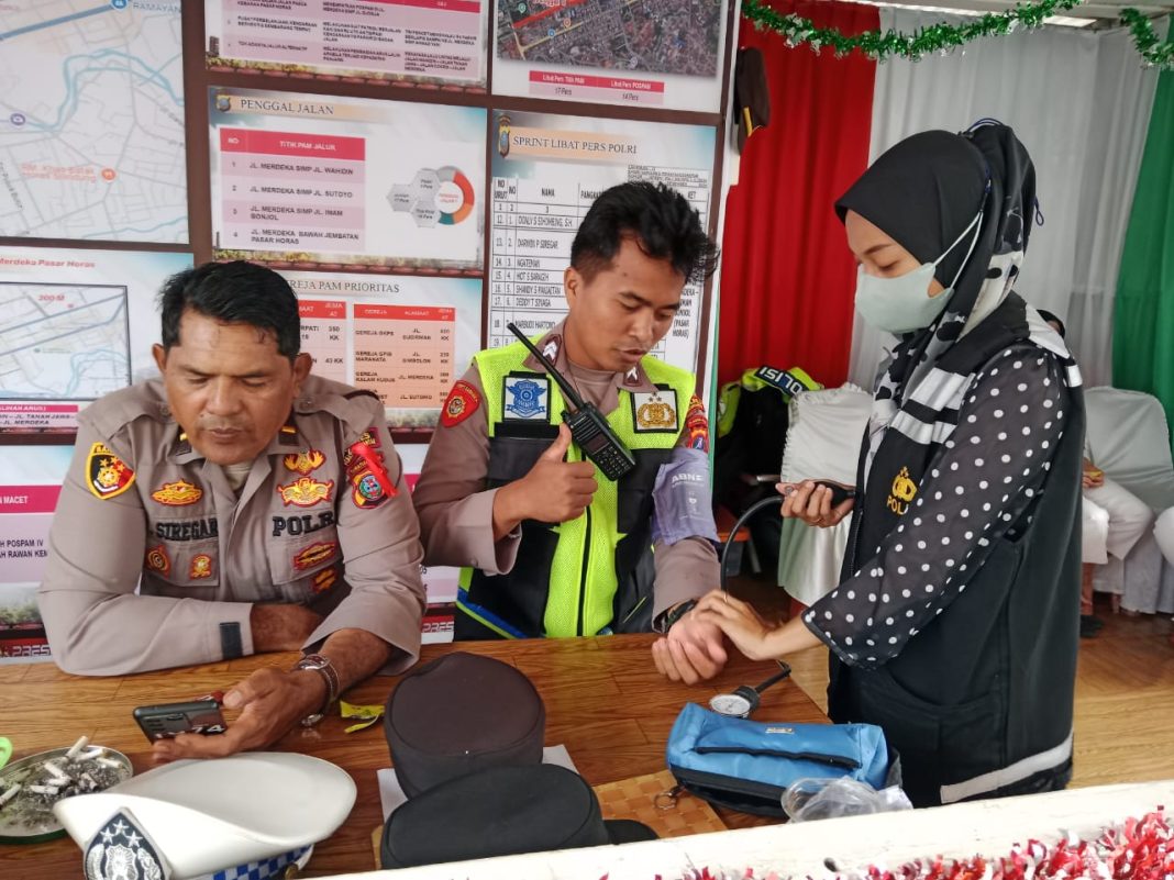 Petugas Dokkes Polres Pematangsiantar saat melakukan pemeriksaan kesehatan personil di Pos Pam dan Pos Yan Ops Lilin Toba di wilayah Kota Pematangsiantar, Kamis (26/12/2024). (Dok/Polres Pematangsiantar)