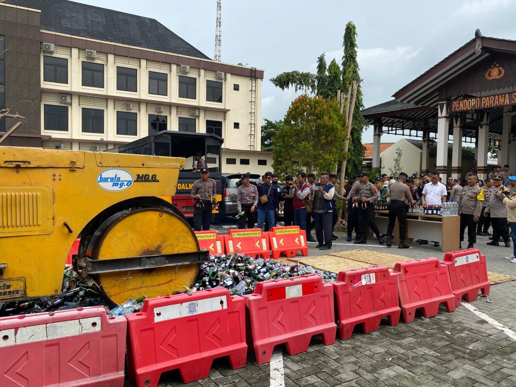 Ribuan botol miras berbagai jenis dimusnahkan menggunakan kendaraan roller di halaman Mapolres Demak, Senin (30/12/2024).