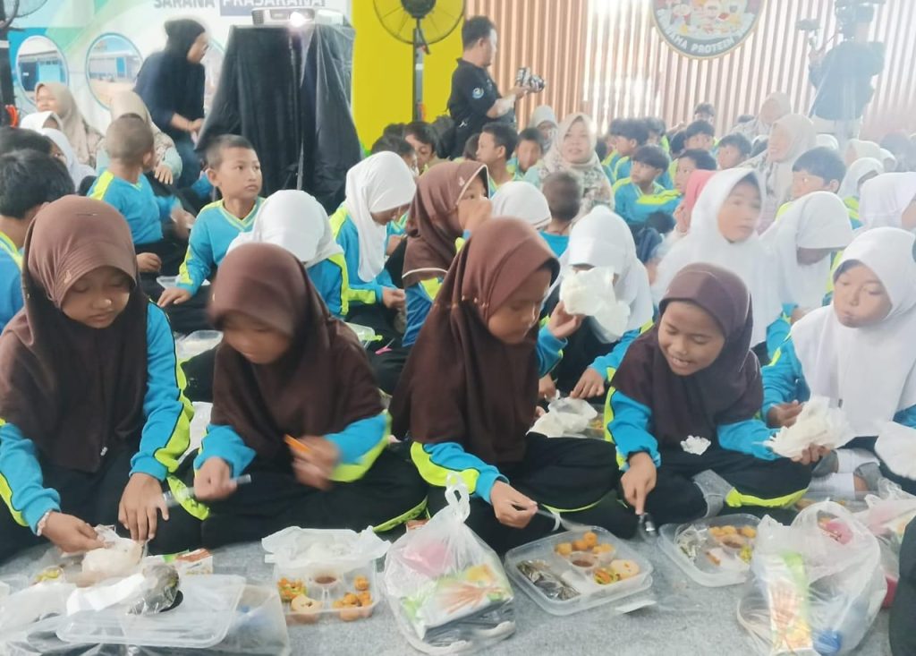Anak-anak menikmati menu ikan dalam program Makan Bergizi Gratis (MBG) yang diluncurkan oleh Kementerian Kelautan dan Perikanan di Technopark Perikanan Pekalongan, Minggu (29/12/2024).