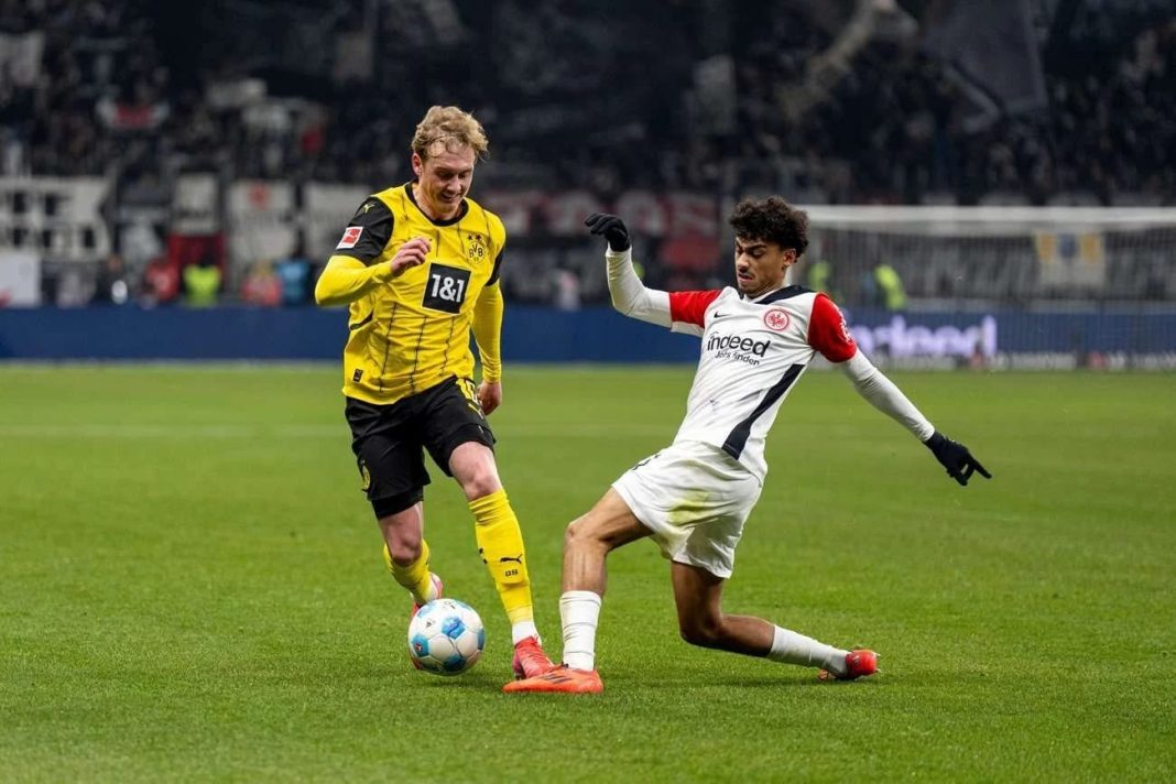 Aksi Gelandang Dortmund Julian Brant saat menggiring bola lewati pemain Frankfurt. Hasil akhir Eintracht Frankfurt vs Borussia Dortmund 2-0 di Deutsche Bank Park, Sabtu (18/1/2025) dini hari WIB.