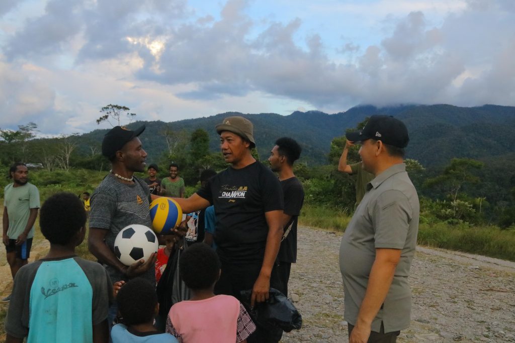 Personel Satgas Ops Damai Cartenz menyerahkan bola kaki dan bola voli kepada masyarakat Yalimo.