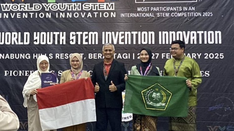 Amirah Zhafirah Yusrah dan Khalisa Danish Ara dari MAN 1 Medan berfoto dengan bendera Indonesia dan bendera madrasah setelah sukses meraih Medali Perak di kompetisi WYSII 2025. (Dok/Kemenag)