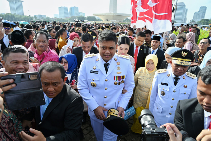 Gubernur Sumatera Utara Bobby Afif Nasution bersama Wakil Gubernur Surya berjalan menuju Istana Negara setelah menghadiri acara di Monumen Nasional, Jakarta, Kamis (20/2/2025). (Dok/Diskominfo Sumut)