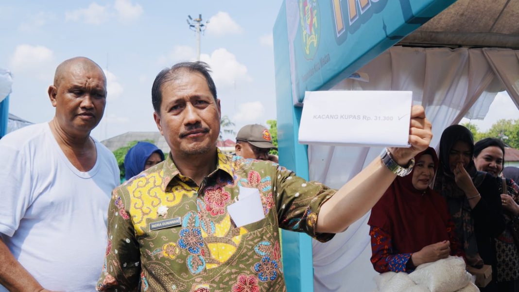 Kabid Perdagangan Disperindag Kota Medan, Indra Gunawan, menunjukkan harga kacang kupas yang dijual di Pasar Murah Pemko Medan, Kamis (20/2/2025). (Dok/Diskominfo Kota Medan)