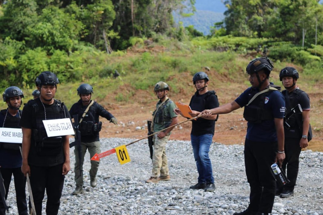 Petugas kepolisian mengawal jalannya rekonstruksi kasus penembakan Brigpol Iqbal Anwar Arif di Kampung Hobakma, Distrik Elelim, Kabupaten Yalimo.