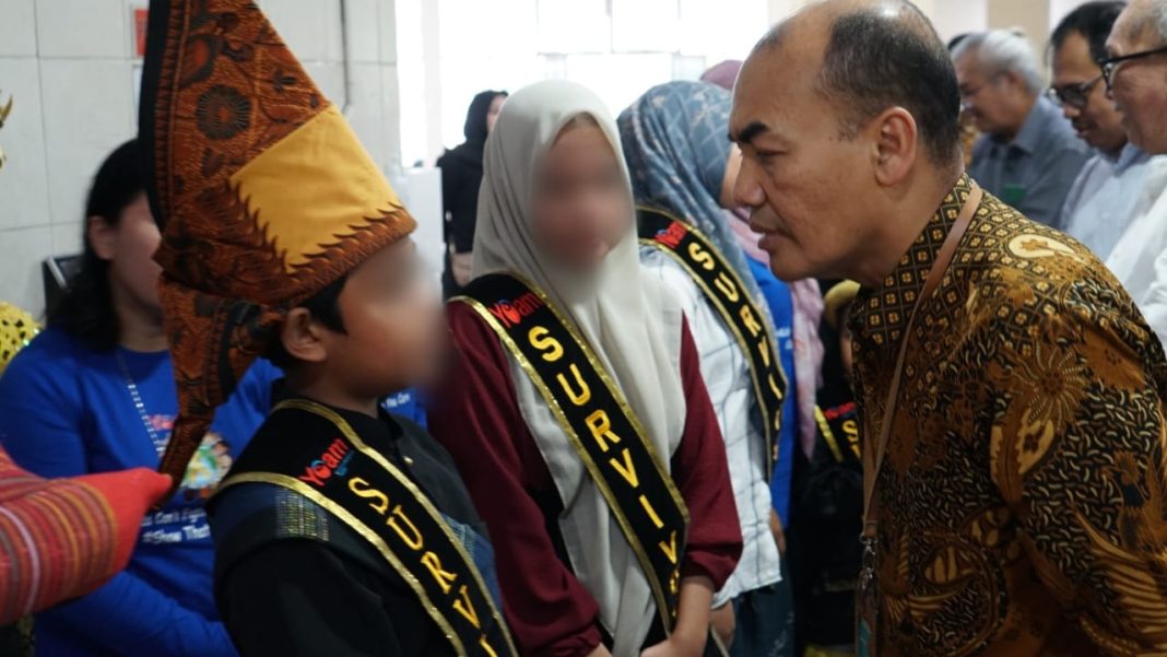 dr Zainal Safri MKed (PD) SpPD-KKV SpJP (K) menyalami anak-anak saat memperingati Hari Kanker Anak Sedunia bersama pasien di selasar Gedung CMU RS Adam Malik, Jumat (14/2/2025). (Dok/Humas RS Adam Malik)