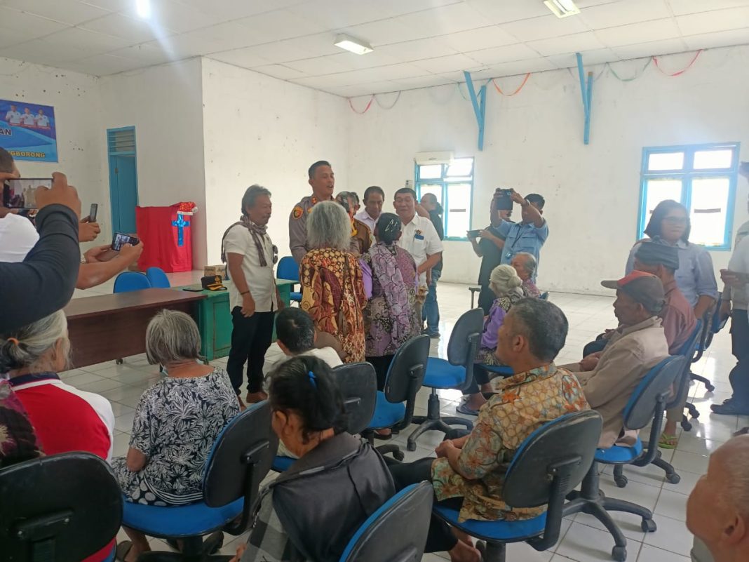 Kapolres Taput AKBP Ernis Sitinjak bersama Ketua PWI Bona Pasogit Alfonso Situmorang didampingi rekan media lain nya saat menyerahkan bingkisan kepada para Lansia di Siborong-borong, Selasa (18/2/2025).