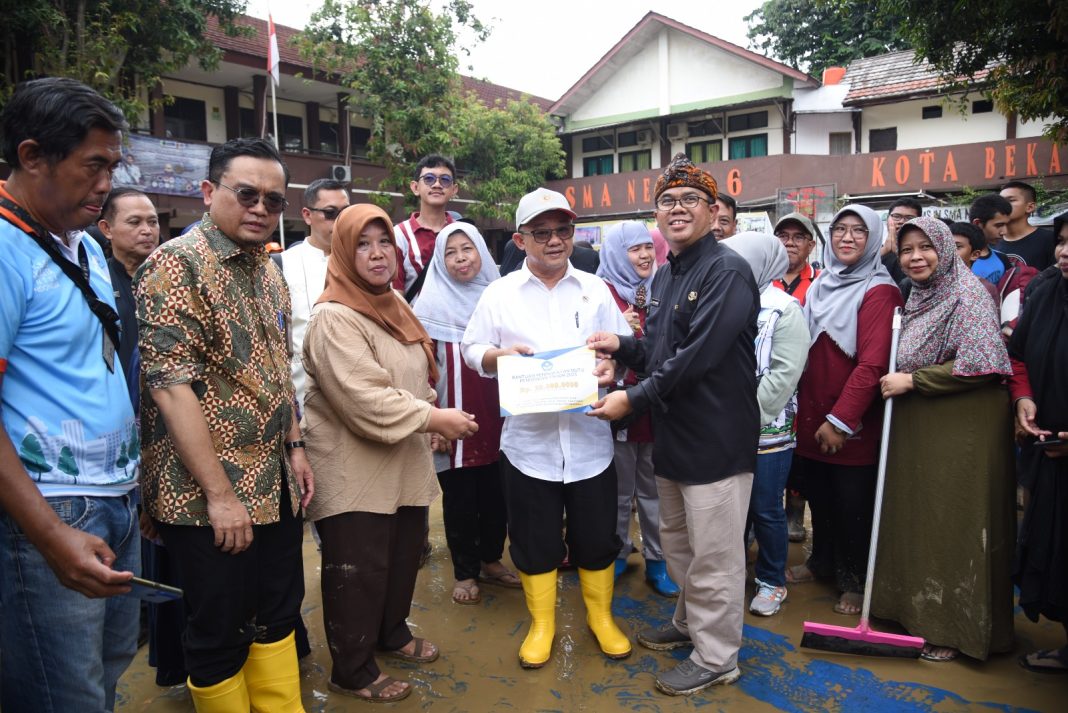 Mendikdasmen, Abdul Mu’ti, menyerahkan bantuan kepada perwakilan sekolah yang terdampak banjir di Kota Bekasi, Kamis (6/3/2025). (Dok/Kemendikdasmen)