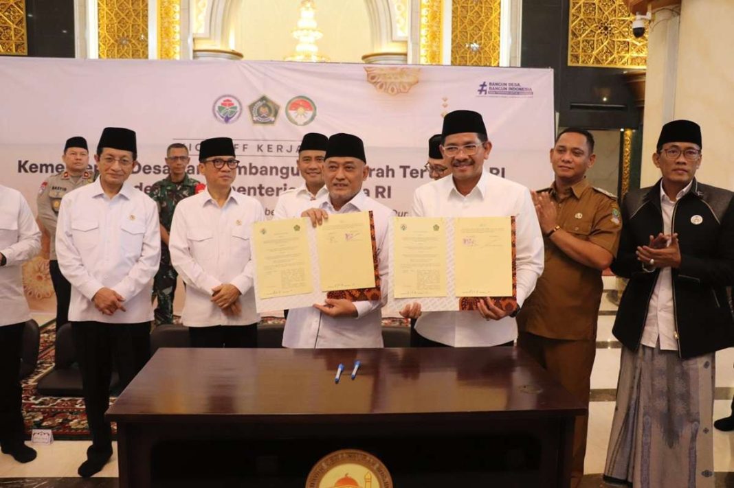 Menteri Desa PDTT Yandri Susanto dan Wabup Bekasi Asep Surya Atmaja menunjukkan dokumen kerja sama usai penandatanganan program pemberantasan buta huruf Al-Qur'an dan satu desa satu majelis taklim, di Masjid Izzatul Islam, Senin (24/3/2025). (Dok/Diskominfo Bekasi)
