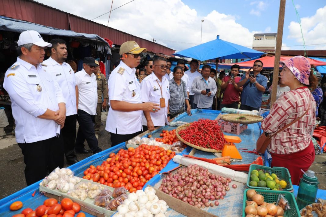 Bupati/Wakil Bupati Taput JTP-Den tampak akrab dengan pedagang saat menanyakan harga berbagai komoditi pertanian di Pasar Tarutung, Rabu (12/3/2025).