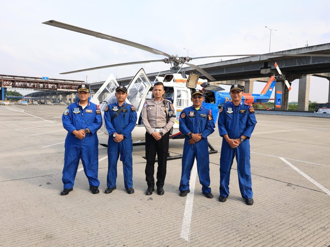 Sejumlah personel Ditpoludara Baharkam Polri bersiap siaga bersama unit helikopter Ambulans Udara di KM 29 Tol Kalikangkung, mendukung kelancaran dan keamanan arus mudik Lebaran 2025.