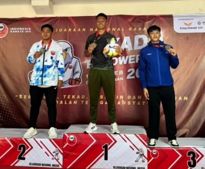 Serda Andri Yudha (tengah) berdiri di podium juara 1 setelah meraih medali emas dalam kategori kumite perorangan senior -84kg putra di Kejuaraan Nasional Inkado Empowering 2025 di GOR Balungan, Jakarta.