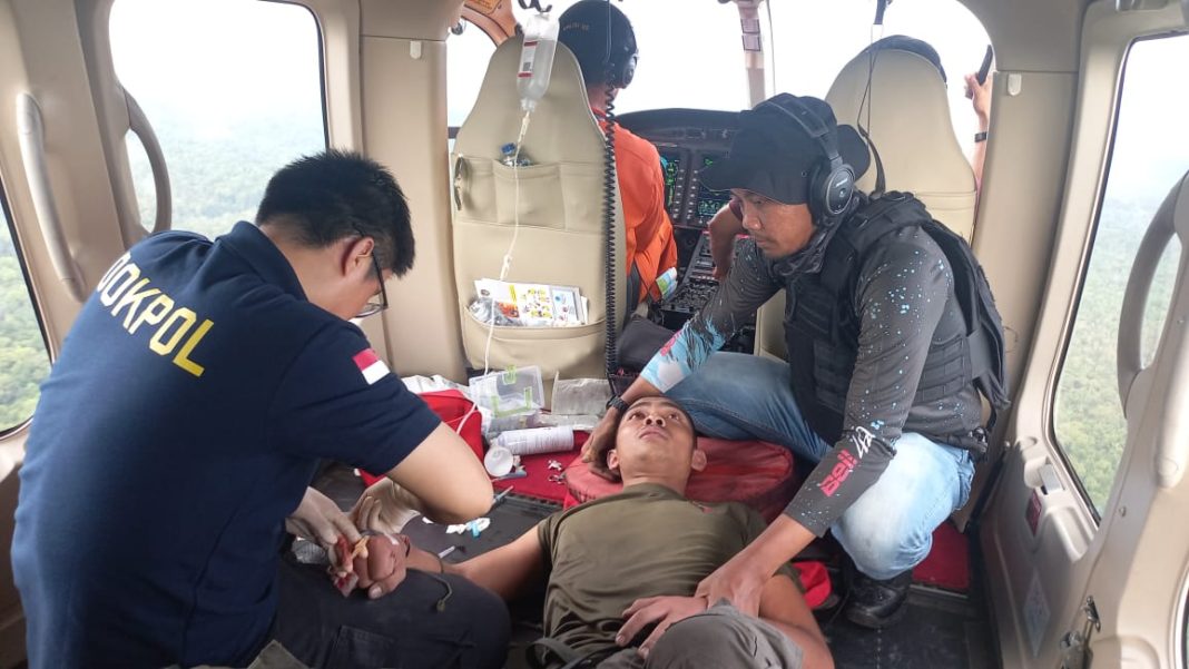 Tim medis Subsatgas Dokkes memberikan pertolongan pertama kepada Bharatu Komang Ngurah di dalam helikopter usai mengalami sengatan lebah saat operasi pencarian Iptu Tomi Samuel Marbun di kawasan hutan Papua, Sabtu (26/4/2025).