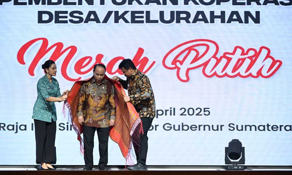Menteri Koperasi dan UMKM Budi Arie Setiadi menerima ulos sebagai tanda penghormatan budaya pada acara Sosialisasi Pembentukan Koperasi Desa/Kelurahan Merah Putih di Aula Raja Inal Siregar, Medan, Rabu (30/4/2025). (Dok/Diskominfo Sumut)