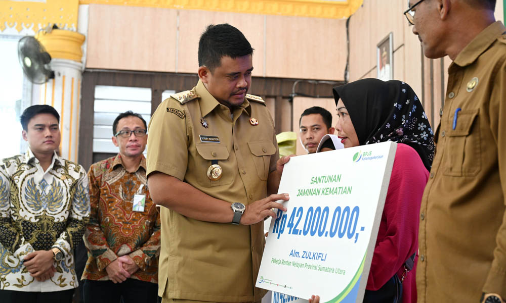 Gubernur Sumut Bobby Nasution menyerahkan santunan jaminan kematian secara simbolis kepada ahli waris nelayan penerima manfaat asuransi BPJS Ketenagakerjaan dalam acara Penyerahan Asuransi Nelayan Provinsi Sumut 2025 di Pendopo Jentera Malay, Kabupaten Langkat, Selasa (6/5/2025). (Dok/Diskominfo Sumut)