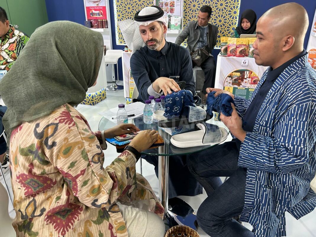 Pendiri jenama Apikmen berdiskusi dengan calon pembeli internasional dalam pameran di Jeddah, Arab Saudi, mempromosikan produk batik dan sandal berbahan warna alam. (Dok/Pertamina)