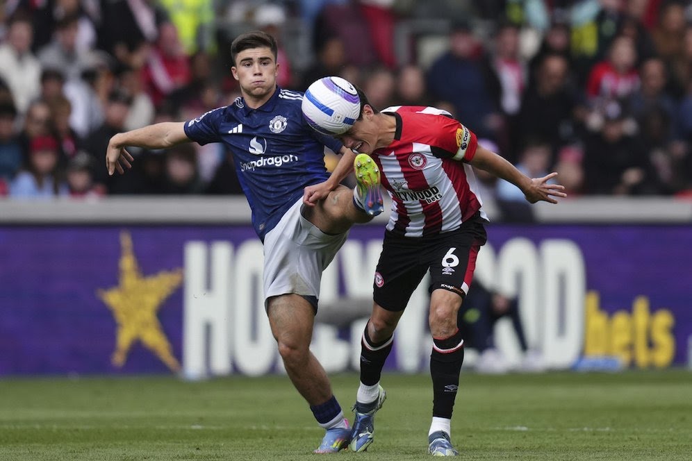 Pemain Manchester United, Harry Amass berebut bola dengan pemain Brentford, Christian Norgaard.