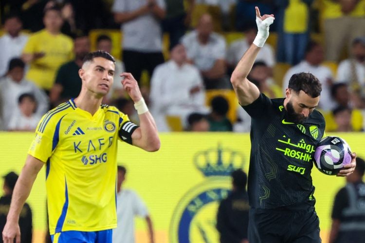 Pemain depan Nassr Cristiano Ronaldo bereaksi saat pemain depan Ittihad Karim Benzema merayakan gol pertama timnya selama pertandingan sepak bola Liga Pro Saudi antara Al-Nassr dan Al-Ittihad di Al-Awwal Park di Riyadh.