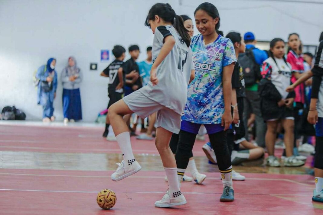 Dua atlet muda tengah berlatih mengasah keterampilan dalam Kejuaraan Sepak Takraw Kadet dan Junior 2025 di GOR Sepak Takraw Lodaya, Bandung.