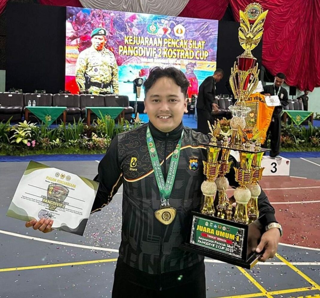 Bripda Sholeh Maulana dari Polsek Babat, Polres Lamongan, berpose dengan medali emas dan trofi Juara Umum 1 setelah tampil gemilang dalam Kejuaraan Terbuka Pencak Silat Pangdivif 2 Cup 2025 di GOR Vira Cakti Yudha, Singosari, Kabupaten Malang, Jawa Timur, Selasa (27/5/2025).
