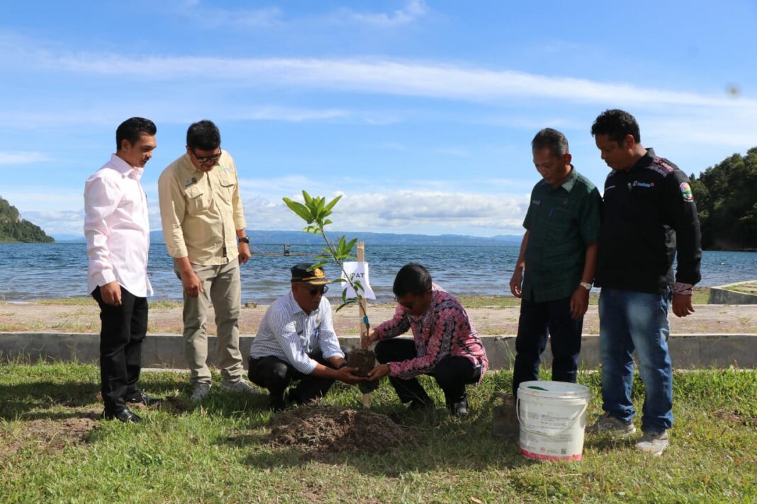 Sekda Toba Drs Augus Sitorus dan staf saat menanam pohon di Desa Meat, Kamis (05/06/2025).