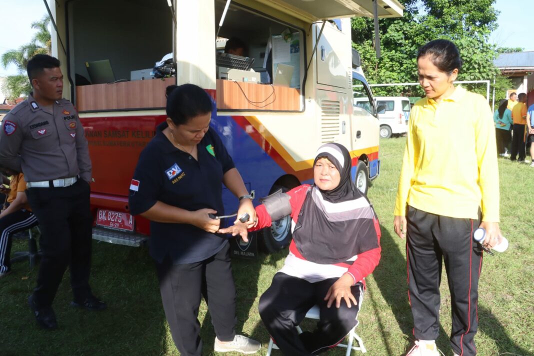 Seorang petugas kesehatan dari Urkes Polres Simalungun memeriksa tekanan darah salah satu peserta Car Free Day di Lapangan Haji Ulakma Sinaga, Kecamatan Siantar, Kabupaten Simalungun, Minggu (8/6/2025).